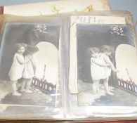 An early 20th century postcard collection in two albums and an empty late Victorian leather photo