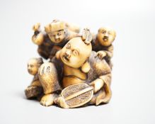 A Japanese ivory netsuke of Hotei with three boys, Meiji period, signed, width 4cm