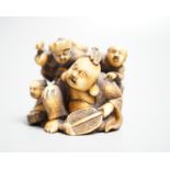 A Japanese ivory netsuke of Hotei with three boys, Meiji period, signed, width 4cm