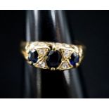 A late Victorian 18ct gold, three stone sapphire and four stone diamond chip set ring, size L, gross