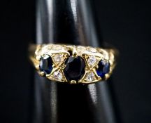 A late Victorian 18ct gold, three stone sapphire and four stone diamond chip set ring, size L, gross