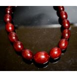 A single strand graduated simulated cherry amber oval bead necklace, 44cm, gross weight 78 grams.