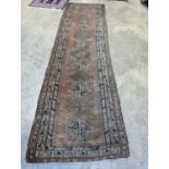 An antique Caucasian red ground runner, 372 x 106cm