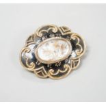 A Victorian yellow metal and black enamel cartouche shaped mourning brooch, with engraved