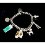 A 9ct curb link charm bracelet, hung with seven assorted charms, gross weight 38.8 grams.