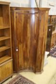 An 18th century North Italian walnut standing corner cupboard with concave door, width 130cm,