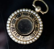 A William IV yellow metal, black enamel and split pearl mounted glazed circular mourning pendant