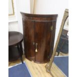 A George III banded mahogany bow front hanging corner cabinet, width 76cm, depth 53cm, height 113cm