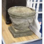 A circular reconstituted stone garden planter on square plinth, diameter 49cm, height 46cm