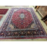 A Kashan burgundy ground carpet, 380 x 300cm