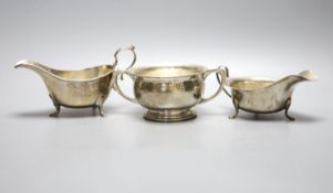 Two George V silver sauceboats and a similar silver two handled sugar bowl, with engraved