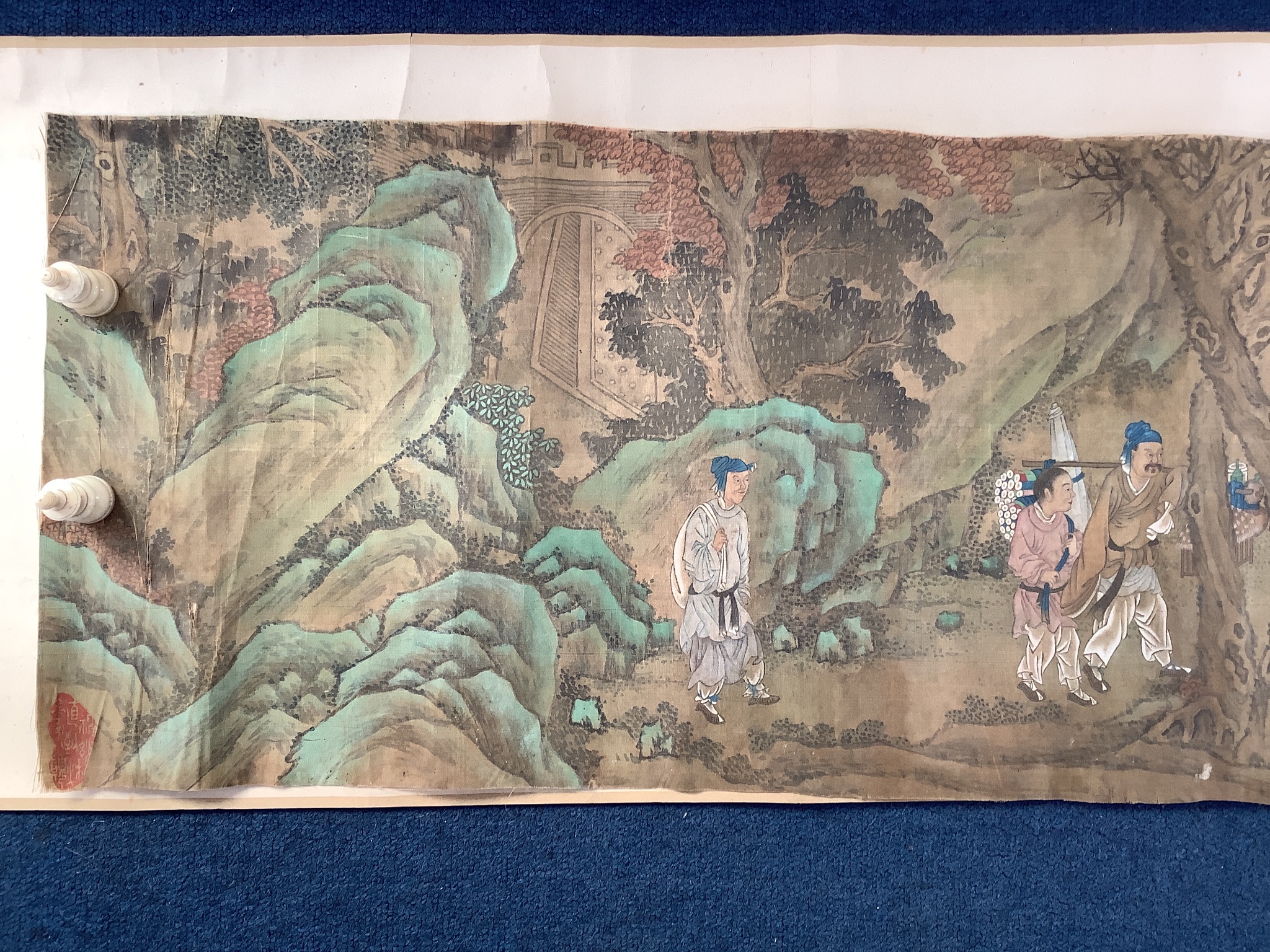 A 19th century Chinese hand scroll painting on silk of figures in a landscape, approximately 206