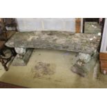 A pair of reconstituted stone garden benches of curved rectangular form with recumbent lion