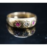 An early 20th century yellow metal and gypsy set ruby and diamond set three stone ring, size O,