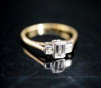 A yellow metal and three stone emerald and square cut diamond set ring, size N, gross weight 2.3