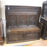 An 18th century and later carved oak settle with hinged box seat, width 137, depth 42, height 137