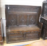 An 18th century and later carved oak settle with hinged box seat, width 137, depth 42, height 137