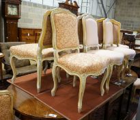 A set of fourteen French Louis XV style painted upholstered dining chairs with loose covers