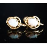 A modern pair of 585 yellow metal and oval white opal set ear clips, 12mm, gross weight 3.2 grams.