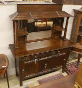 An early 20th century Arts & Crafts oak and polished steel mirrored sideboard, in the manner of