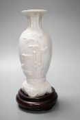 A Chinese 'deer and bamboo' moulded porcelain vase, 19th century, wood stand, height overall 20cm