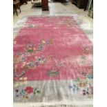 A large early 20th century Chinese cerise ground floral ground carpet, 530 x 358cm