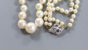 A double strand graduated cultured pearl necklace, with white metal (18ct poincon mark), sapphire
