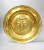 A large Nuremberg brass alms dish, 17th century, depicting Adam and Eve within a twisted foliate and