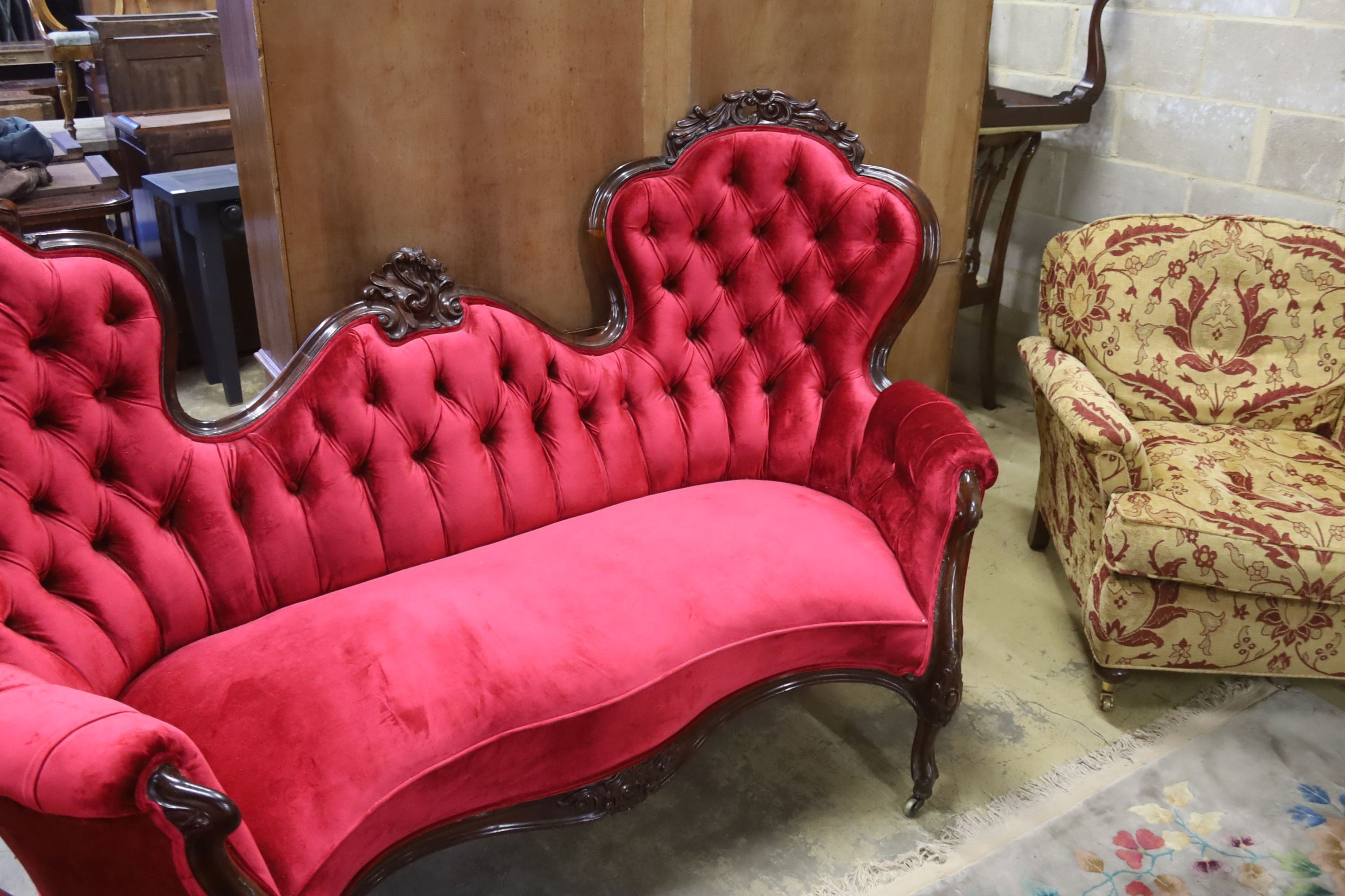 A Victorian carved rosewood double spoon back settee upholstered in deep buttoned scarlet velvet, - Image 2 of 5