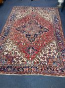 A Heriz brick red ground carpet, 326 x 240cm