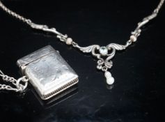 A modern silver pendant necklace, a silver vest case and a sterling chain.