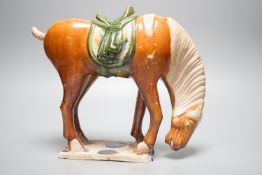 A Chinese Tang style sancai pottery horse, 21cm high