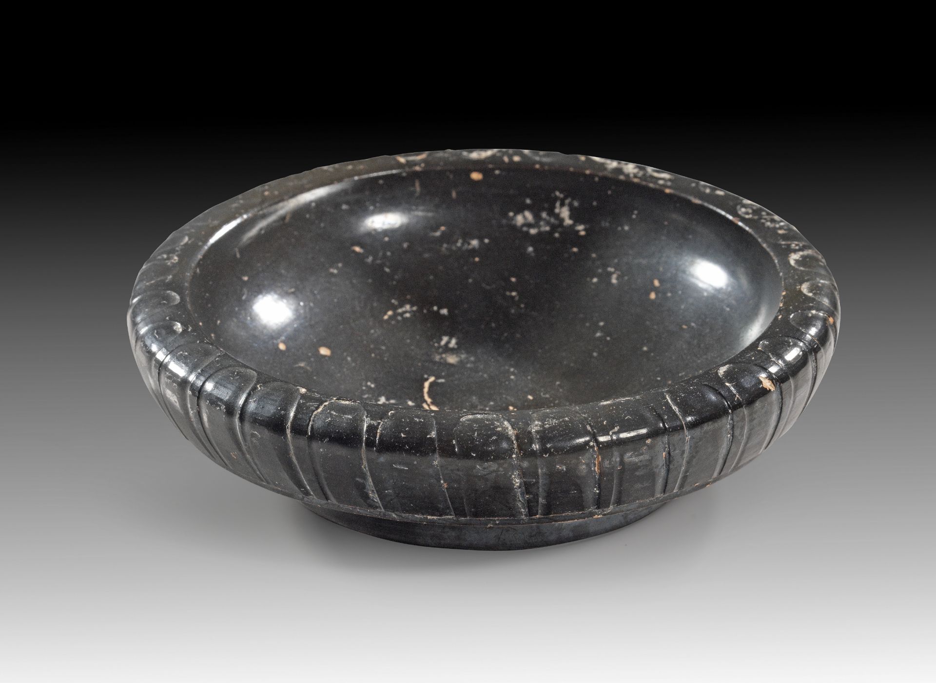 Small Apulian black-glaze dish with ribbed rim.