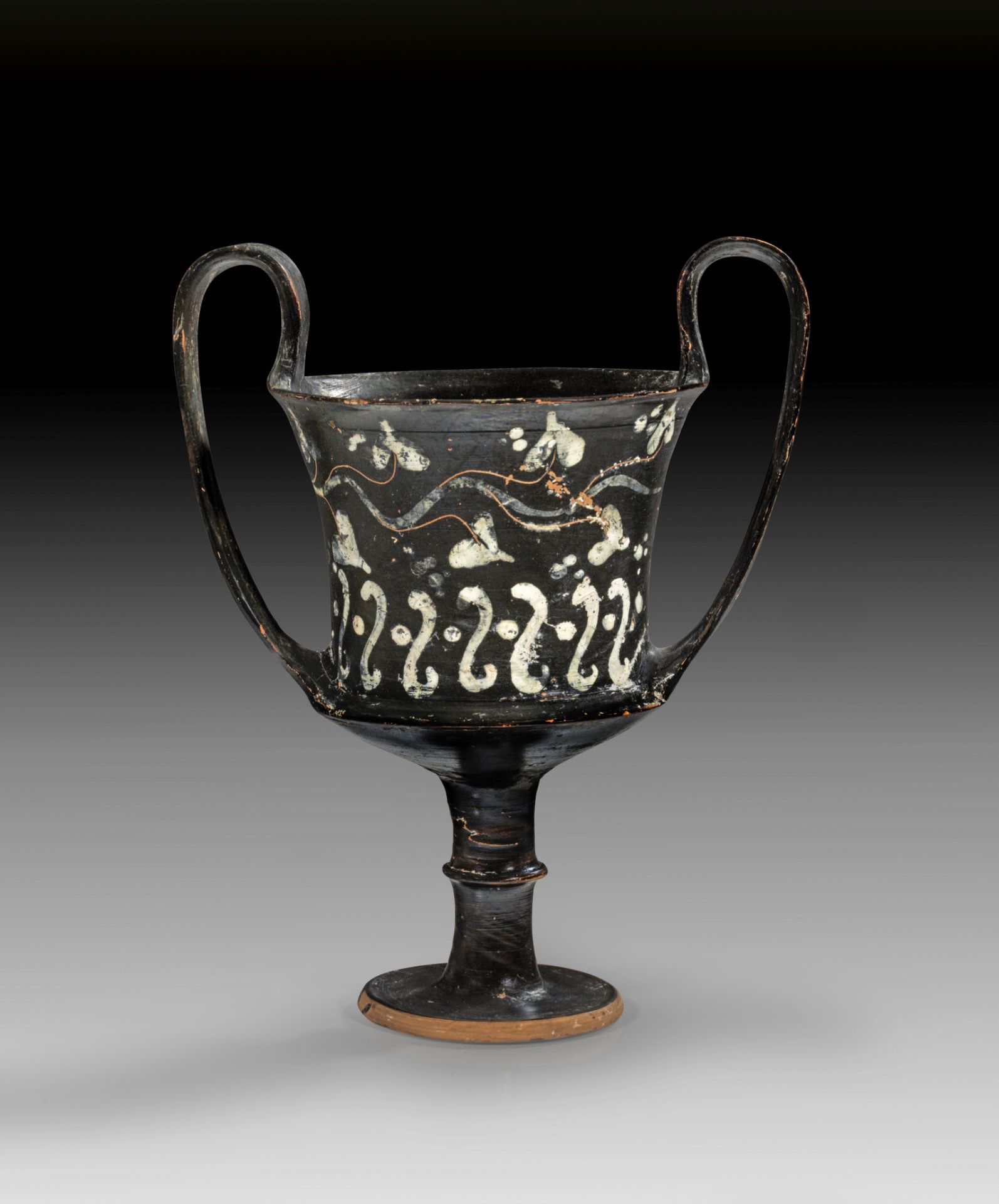 Black-glaze kantharos with engraved tendril and white painted ivy-leaves.