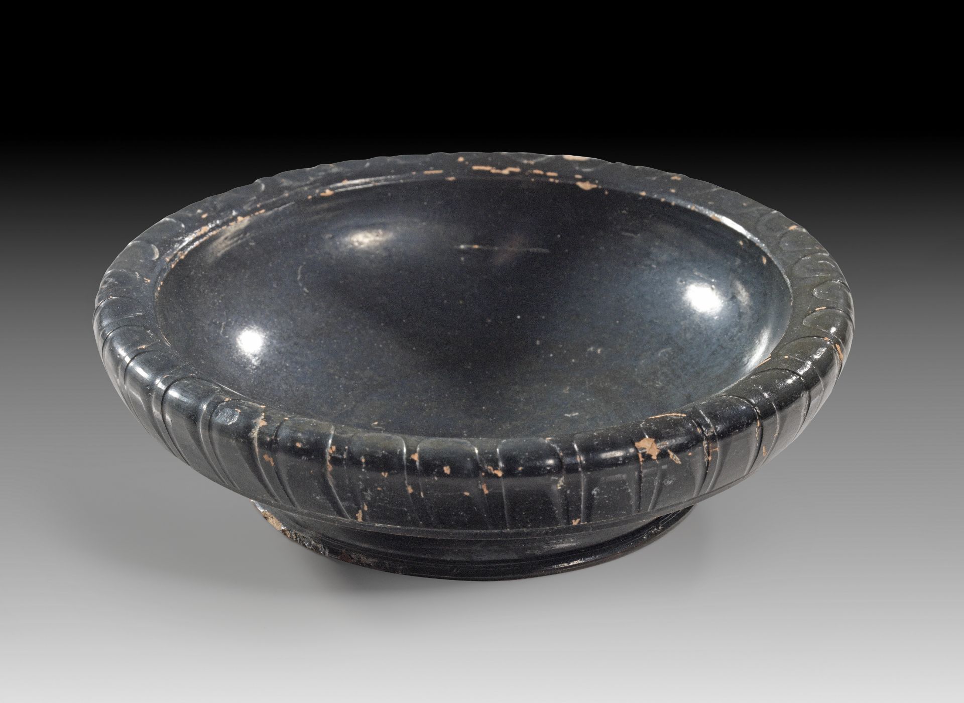 Small Apulian black-glaze dish with ribbed rim.