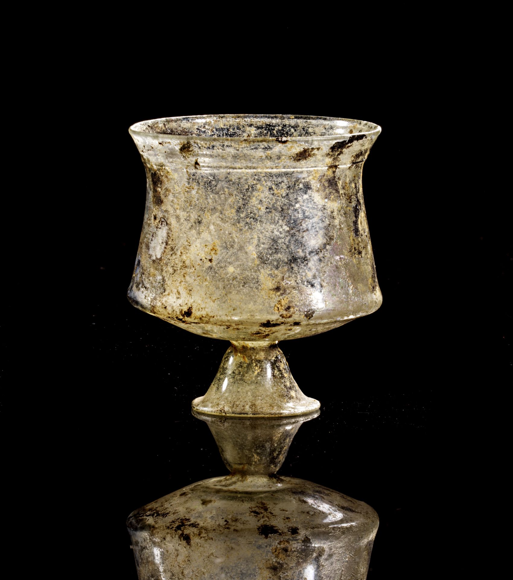 Roman clear glass beaker on conical foot.