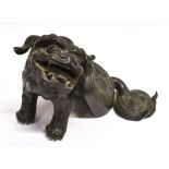 A CHINESE BRONZE FIGURAL INCENSE BURNER modelled as a dog of Fo type figure, seated scratching his