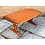 AN ERCOL 'GOLDEN DAWN' COFFEE TABLE on shaped end supports united by stretcher, 68cm x 127cm, 51cm