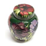 A MOORCROFT POTTERY GINGER JAR AND COVER decorated in the 'Anemone Tribute' pattern on a green/