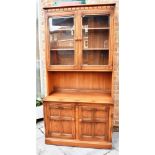 AN ERCOL 'GOLDEN DAWN' DISPLAY CABINET from the 'Old Colonial' Mural range, the top with pair of