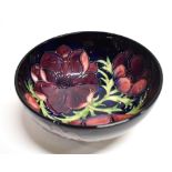 A MOORCROFT POTTERY BOWL DECORATED IN THE 'ANEMONE' PATTERN on a dark blue ground, impressed and