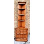 A PAIR OF ERCOL 'GOLDEN DAWN' OLD COLONIAL MURAL CORNER SHELF UNITS with handed cupboard bases (