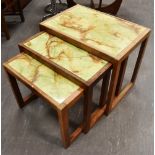 A NEST OF THREE GRADUATED TEAK FRAMED COFFEE TABLES with green faux marble inset tops, the largest