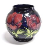 A MOORCROFT POTTERY 'ANEMONE' PATTERN VASE of globular form, tubelined decoration on a dark blue