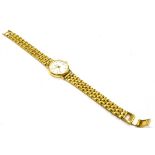 A LADIES 9CT GOLD ZENITH WRISTWATCH on a plated steel bracelet, the round white dial with date