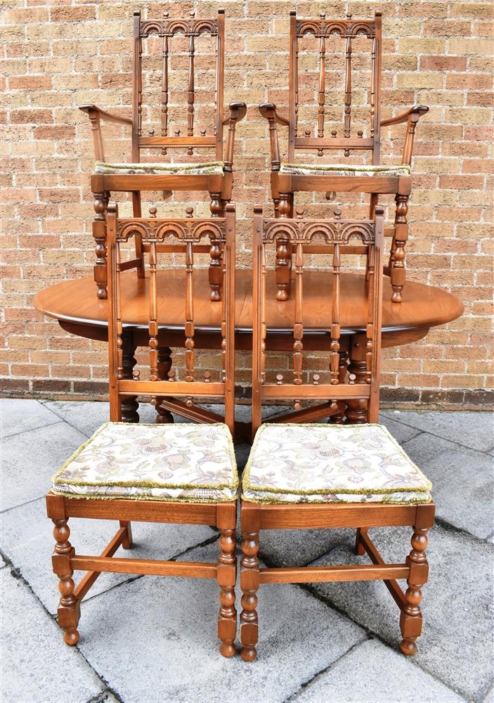 AN ERCOL 'GOLDEN DAWN' EXTENDING DINING TABLE and set of four chairs including pair of carvers