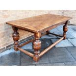 A RUSTIC HARDWOOD DINING TABLE the single plank top with cleated ends, on bulbous supports united by