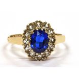 A 9CT GOLD BLUE AND WHITE STONE OVAL CLUSTER RING the central synthetic blue spinel surrounded by