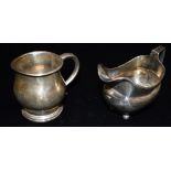 A GEORGIAN SILVER MILK JUG of plain cushion shape with line border 12cms long, on four ball feet