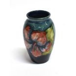 A SMALL MOORCROFT POTTERY VASE DECORATED IN THE 'HIBISCUS' PATTERN on a blue ground, paper label